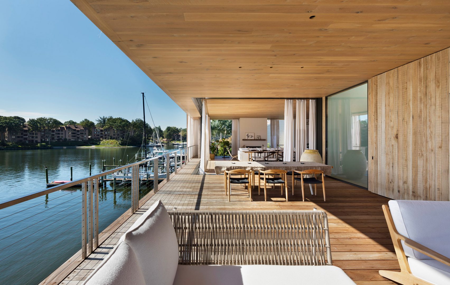 Bates Masi, wooden home, sailing family, Annapolis, waterfront, New York, Chesapeake Bay, Acton Cove, Maryland, capital city, Us Naval Academy, dock, boat, residence, boating, sliding glass door, curtain, indoor, outdoor, privacy, weather, living room, cantilevered decks, balcony, Acton Cove, modern, nautical aesthetic, white walls, cabinet, furniture, kitchen, couch, six PP503 chair, Hans J Wegner, swimming pool, dock, pool, bedroom, en-suite bathroom, Acton House, garage, studio, garden, Virginia-based Gregg Bleam
